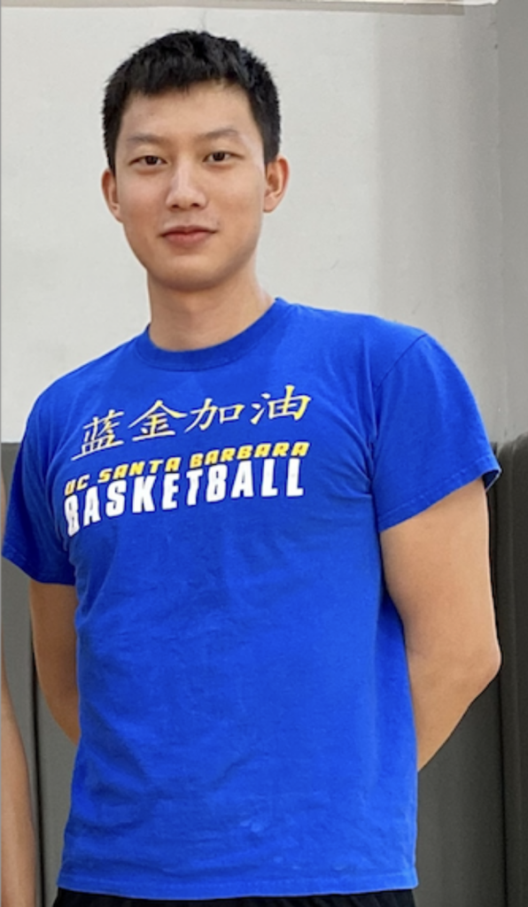 Alt Text: A picture of Jiarun Lu, a Chinese-American person. They have short black hair, brown eyes, and medium light skin. He is wearing a blue shirt that has four Simplified Chinese characters on it followed by the text “UC Santa Barbara Basketball” in English. 